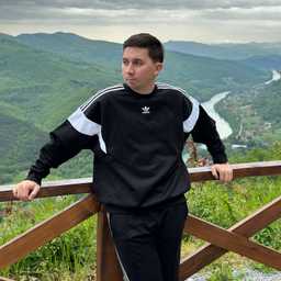 Photo of me in Adidas tracksuit. I'm standing at the edge of a cliff – national park.